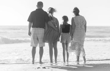 man and woman walking on beach during daytime